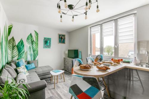 - un salon avec un canapé et une table avec de la nourriture dans l'établissement Naturéa- Saint-Julien-les-villas, à Saint-Julien-les-Villas