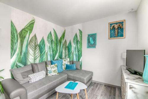- un salon avec un canapé et une fresque murale dans l'établissement Naturéa- Saint-Julien-les-villas, à Saint-Julien-les-Villas