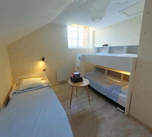 SoulanにあるSport et réconfort en Couseransのベッドルーム1室(二段ベッド2組、テーブル付)