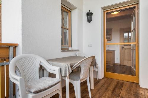 a dining room with a table and chairs and a window at Kranebitterhof Apt Alpenrose in Valdaora