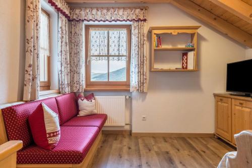 a living room with a pink couch and a window at Kranebitterhof Apt Alpenrose in Valdaora