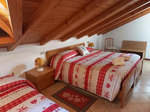 1 Schlafzimmer mit 2 Betten und Holzdecke in der Unterkunft B&B Piazzi di Katia in Caderzone