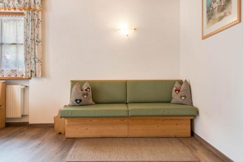a living room with a green couch in a room at Kranebitterhof Apt Edelweiss in Valdaora