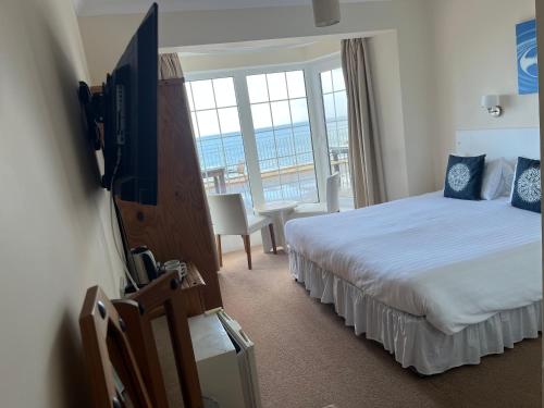 a hotel room with two beds and a flat screen tv at The Prince Of Wales Hotel in St Ouen's