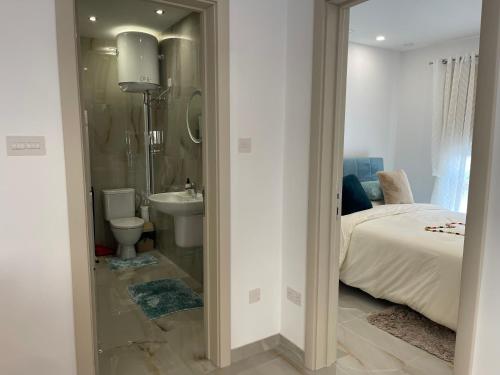 a bathroom with a bed and a toilet and a sink at Maranello Court, Apartment 1 in Marsaxlokk