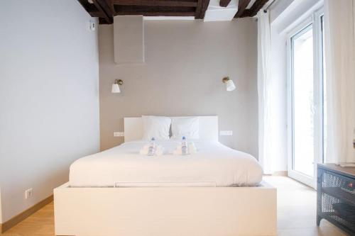- une chambre dotée d'un lit blanc avec deux figurines dans l'établissement AmazingStudio#4pers#terrasse#Marais, à Paris
