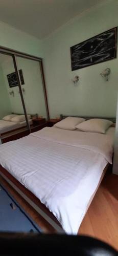 a bedroom with a bed with white sheets and a mirror at Apartments on Independence Square in Kyiv