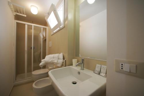 une salle de bain blanche avec un lavabo et des toilettes dans l'établissement Scudaniglio Apartments, à Trapani
