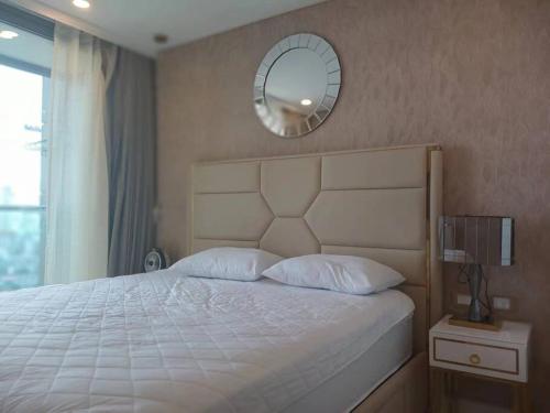 una camera da letto con un letto con uno specchio sul muro di Copacabana 绝美海景房 59楼无边泳池05 a Jomtien Beach