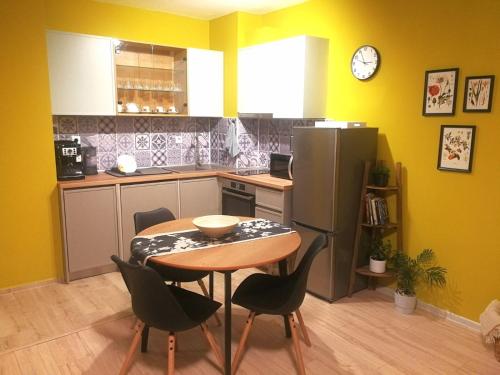 a small kitchen with a table and a refrigerator at Kalina Apartment Kazanlak in Kazanlŭk