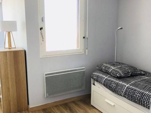 une petite chambre avec un lit et une fenêtre dans l'établissement Studio Cabine Renové à 200m de la Plage - Parking Privé - FR-1-433-37, à Arcachon
