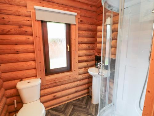 a bathroom with a toilet and a window at 10 Water's Edge in Morpeth