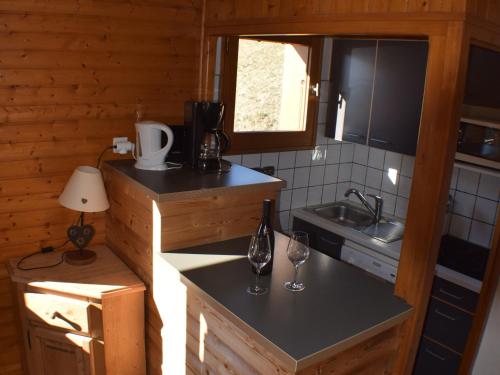 - une cuisine avec 2 verres à vin sur un comptoir dans l'établissement Appartement 3 chambres avec balcon et parking proche pistes - 6 personnes Le Grand-Bornand - FR-1-467-24, au Grand-Bornand