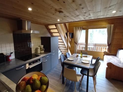 - une cuisine et une salle à manger avec une table et un bol de fruits dans l'établissement Appart. cosy 5 pers. proche pistes et navette, balcon sud - FR-1-467-26, au Grand-Bornand