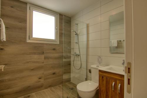 uma casa de banho com um chuveiro, um WC e um lavatório. em Phaedrus Living Coral Suites Harmony em Lárnaca
