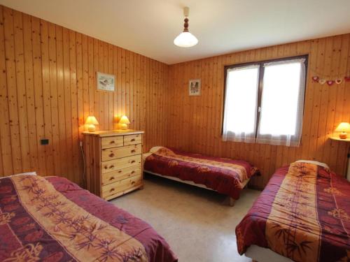 une chambre avec deux lits et une commode et une fenêtre dans l'établissement Appartement 6 pers, 54m², à 400m des pistes, Le Grand-Bornand Village, animaux admis - FR-1-467-76, au Grand-Bornand