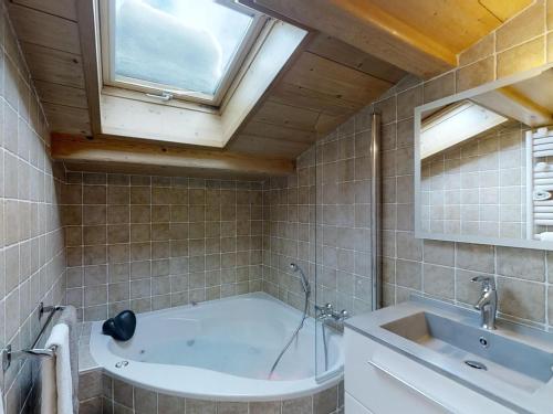 ein Badezimmer mit Badewanne und Waschbecken und einem Fenster in der Unterkunft Appartement 4 pers. chaleureux près des pistes, Le Grand-Bornand - FR-1-467-46 in Le Grand-Bornand