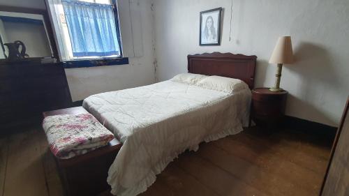 ein Schlafzimmer mit einem Bett, einer Lampe und einem Fenster in der Unterkunft Casa do Barão, São José das Três Ilhas in Belmiro Braga