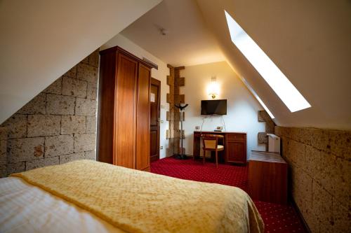 ein Schlafzimmer mit einem Bett und einem Schreibtisch in einem Zimmer in der Unterkunft House of Dracula Hotel in Poiana Brașov