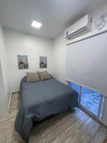 1 dormitorio con 1 cama en una habitación blanca en Departamento en vicente López … sentite en tu casa en Florida