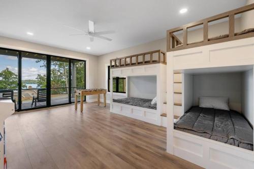 two beds in a room with wood floors and windows at New Home, Dock, Kayaks, Game Room, Water Views in Winchester