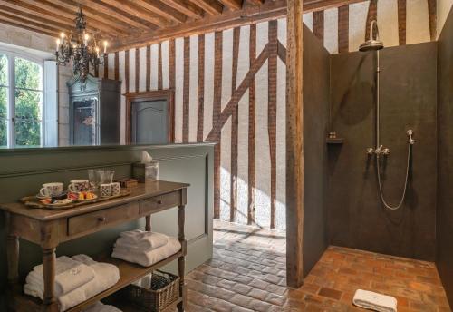 a bathroom with a shower and a table with towels at Domaine de la Blonnerie in Feings