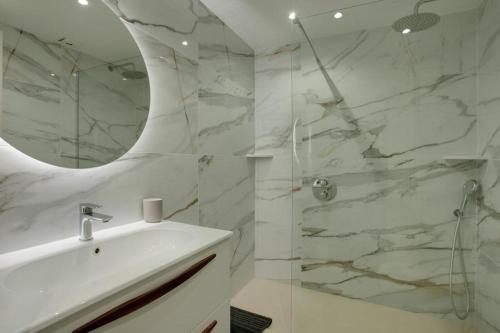 ein weißes Badezimmer mit einem Waschbecken und einem Spiegel in der Unterkunft Apartamento Mirador - Marina Bay in Estepona