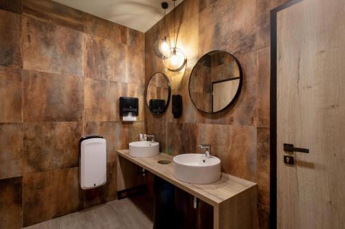 łazienka z 2 umywalkami i lustrem w obiekcie Penzion Racek w mieście Tuchlovice