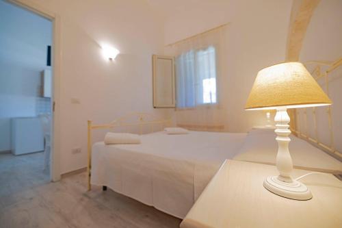 a bedroom with a bed and a lamp on a table at Agriturismo Le Tagliate in Uggiano la Chiesa