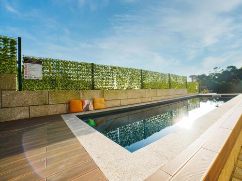 a swimming pool with a retaining wall next to it at Magníficos Dias Atlânticos in Moledo