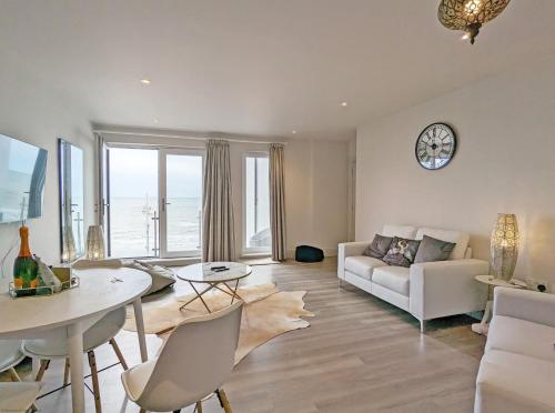 a living room with a white couch and a table at West Lodge, Bognor Regis in Bognor Regis