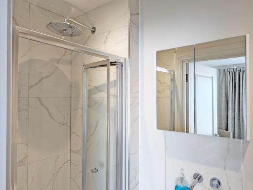 a bathroom with a shower and a mirror at West Lodge, Bognor Regis in Bognor Regis