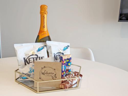 a bottle of champagne and some boxes on a table at West Lodge, Bognor Regis in Bognor Regis