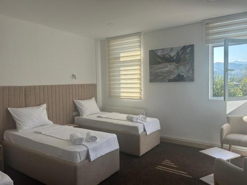 2 camas en una habitación de hotel con ventana en Naš Dom Hotel en Bijelo Polje
