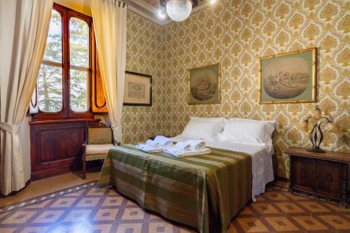 een slaapkamer met een bed met twee handdoeken erop bij Palazzo Tombesi Trecci in Montepulciano