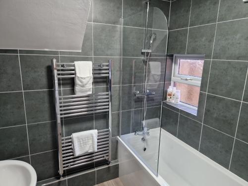 uma casa de banho com um chuveiro, uma banheira e um lavatório. em Birtley's Amethyst, 3 bedroom Apt ,sleeps 6 Guest em Birtley