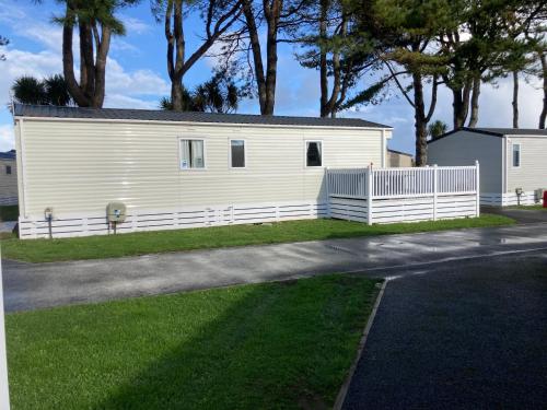 a white house with a fence in the grass at B3 Sunny Tides in Brixham