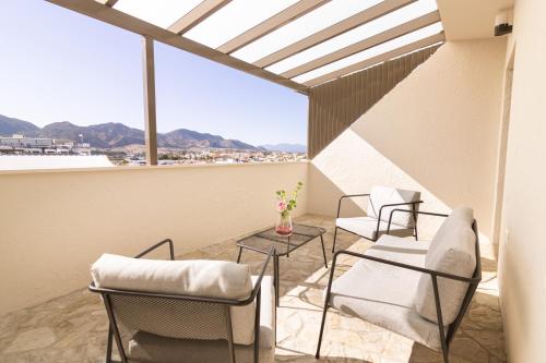 Un balcón con sillas y una mesa con vistas. en Gce Hoteles, en Cártama
