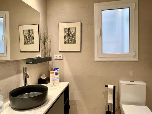 ein Bad mit einem schwarzen Waschbecken und einem WC in der Unterkunft Ancora Apartment in Vilanova i la Geltrú