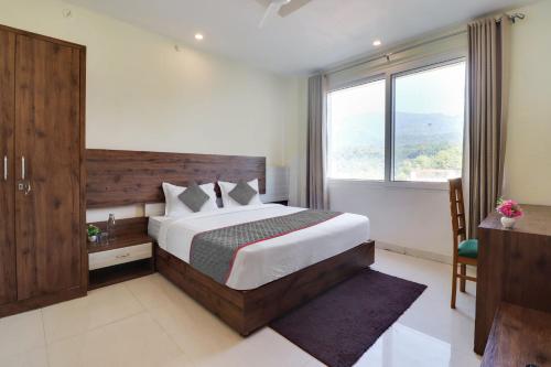 a bedroom with a large bed and a window at Townhouse Hotel Rooftop in Rishīkesh