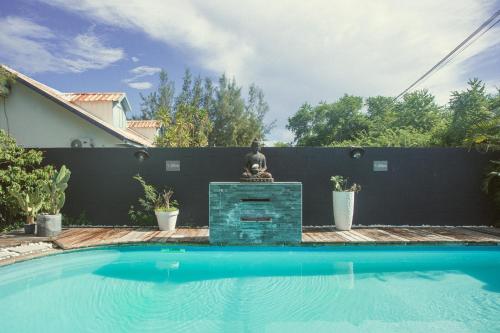 una piscina con fontana di fronte a una recinzione di 1- VACOA - CHAMBRE 1 - Rdc G a La Saline Le Bains