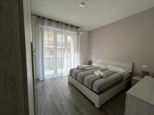 1 dormitorio con cama y ventana grande en Treviolo - Immobili e Soluzioni Rent, en Treviolo