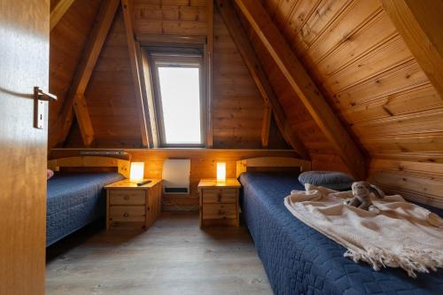 een slaapkamer op zolder met 2 bedden en een raam bij TP30 - Strandvogt 2 Komfort in Dorum Neufeld