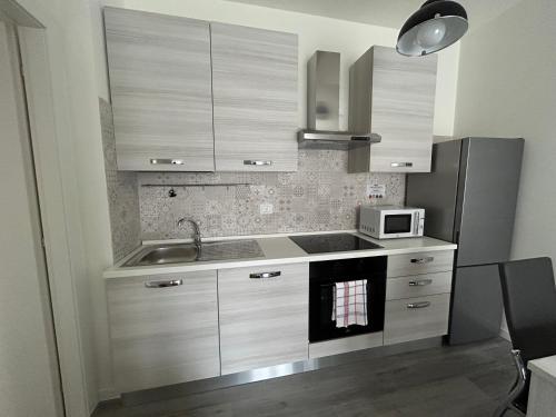 a kitchen with a sink and a microwave at Treviolo - Immobili e Soluzioni Rent in Treviolo