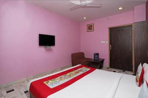 a bedroom with a large bed and a tv on the wall at HOTEL HAYAT RESIDENCY in Jaipur