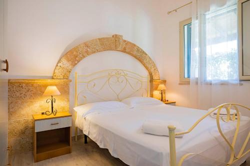 una camera con un letto bianco e una finestra di Agriturismo Le Tagliate a Uggiano la Chiesa