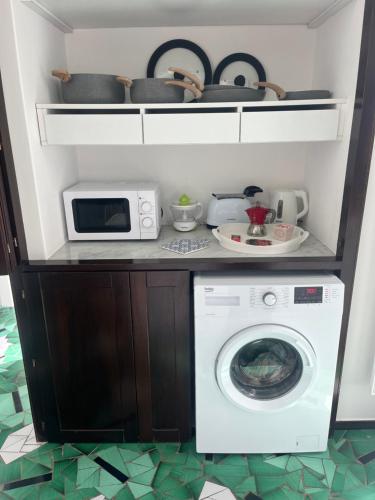 a kitchen with a washing machine and a microwave at Casa Positano in Positano