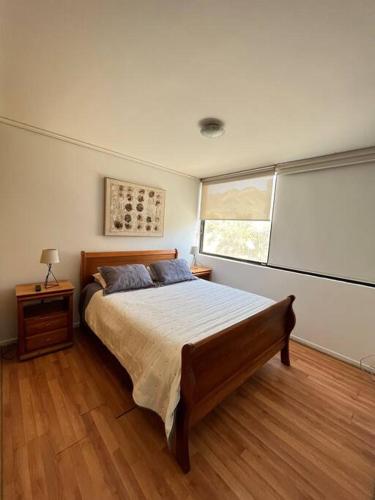 een slaapkamer met een groot bed en een raam bij Exclusivo y cómodo departamento in Copiapó