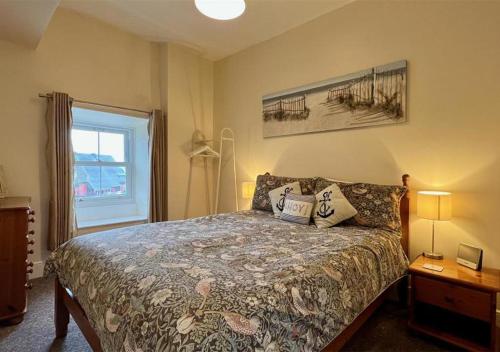 sypialnia z łóżkiem i oknem w obiekcie Luxury 4 Bedroom Seaside Apartment - Glan Y Werydd House w mieście Barmouth