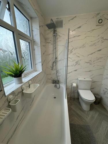 y baño con bañera, aseo y lavamanos. en Smart ROOMS Easy access to Central London By Piccadilly Line en New Southgate